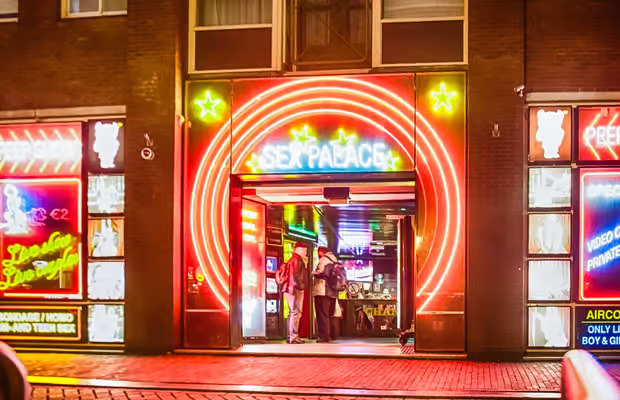 Couple enjoying private Amsterdam red light district coffee shop tour with personalized local guide