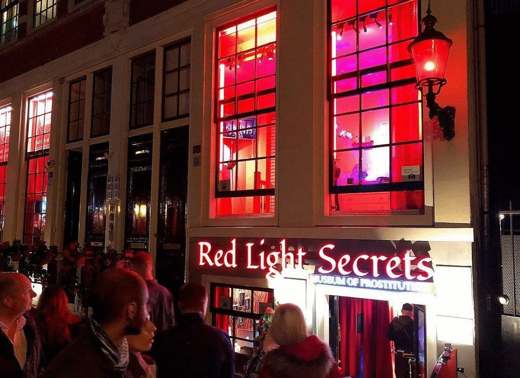 Travelers on Amsterdam red light district tour with local resident guide sharing neighborhood secrets
