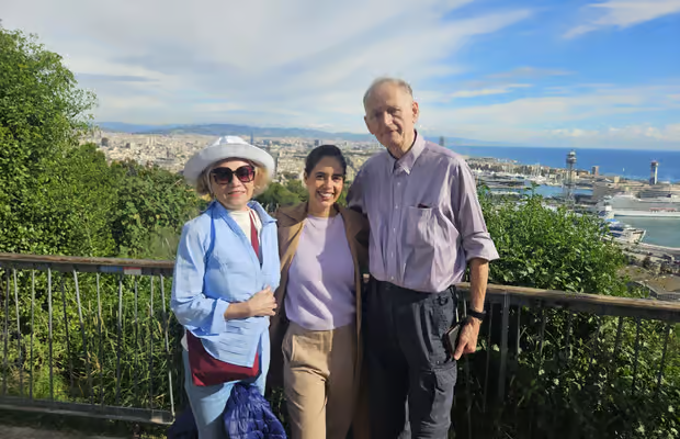 Walking tour group at cable car station with professional guide explaining Barcelona landmarks below