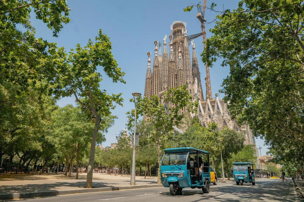 Friends enjoying private Barcelona tuk tuk tour along Passeig de Gràcia in afternoon light