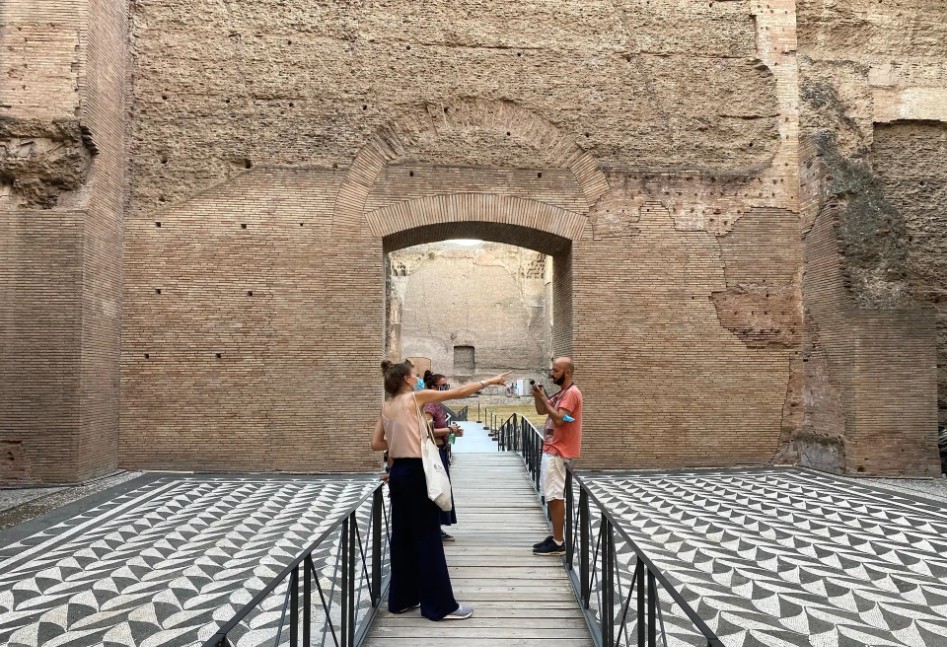 baths of caracalla tickets image showing visitors walking through the ancient brick arches and ruins of the Roman baths in Rome