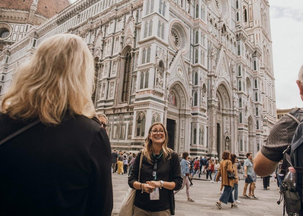 A Florence walking tour group exploring Piazza del Duomo with the ornate Florence Cathedral marble facade in the background