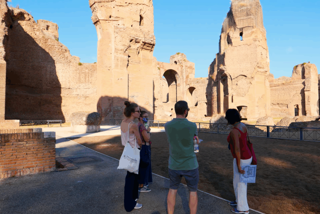 baths of caracalla tickets image showing visitors standing among the towering ancient walls and ruins of the Roman bath complex