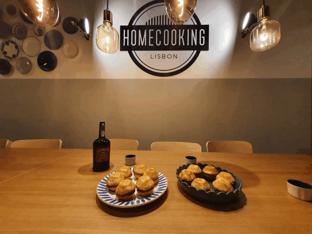 Friends practicing pastel de nata cooking class Lisbon in authentic downtown bakery setting