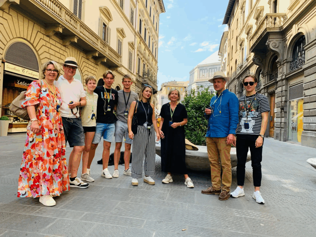 Guided Florence highlights walking tour with travelers photographing the Ponte Vecchio bridge and Arno River views