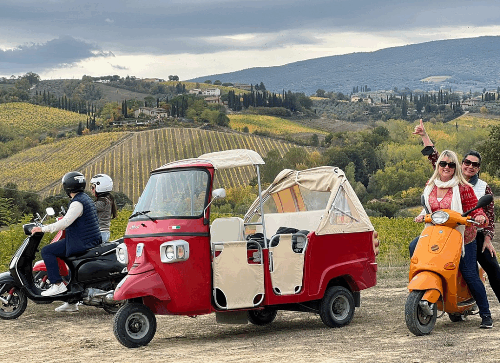Solo traveler on vespa tour Tuscany passing medieval San Gimignano towers during afternoon ride