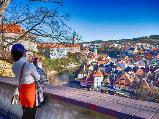 Day trips from Prague to Český Krumlov, with a visitor overlooking the historic Old Town and Vltava River