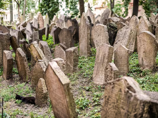 Prague Jewish Quarter walking tour highlighting the Old Jewish Cemetery with densely packed, centuries-old gravestones and moss-covered stone markers
