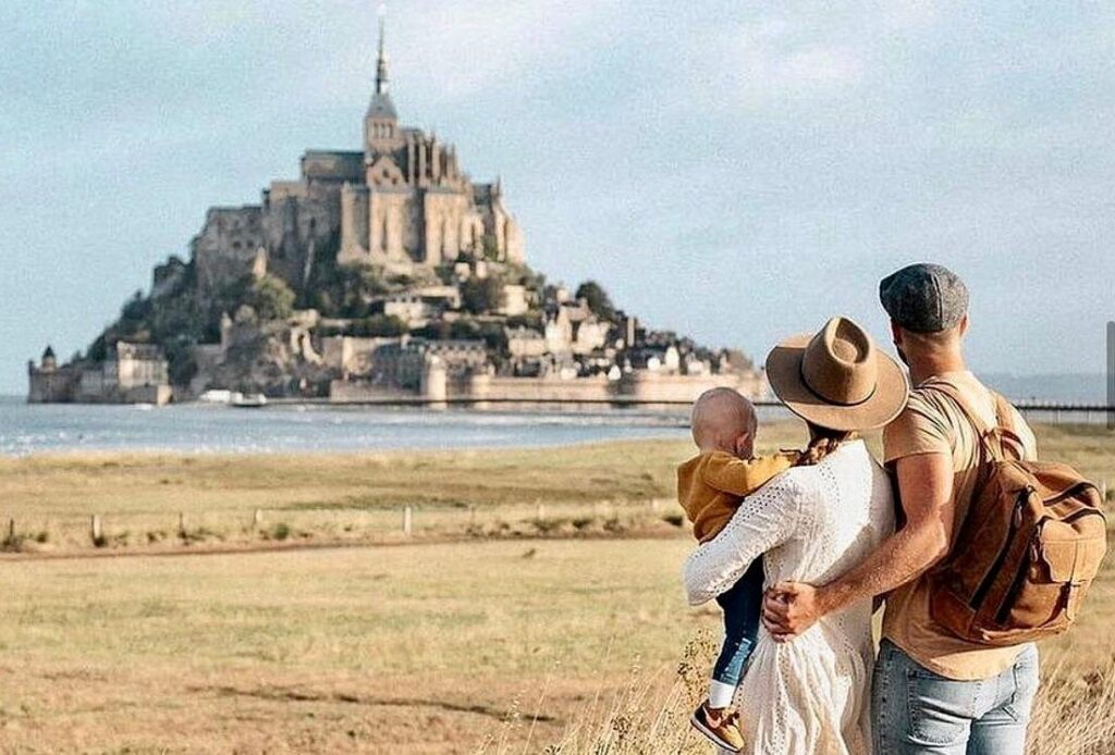 Mont Saint Michel tours featuring a family overlooking the island abbey and medieval village from the mainland viewpoint