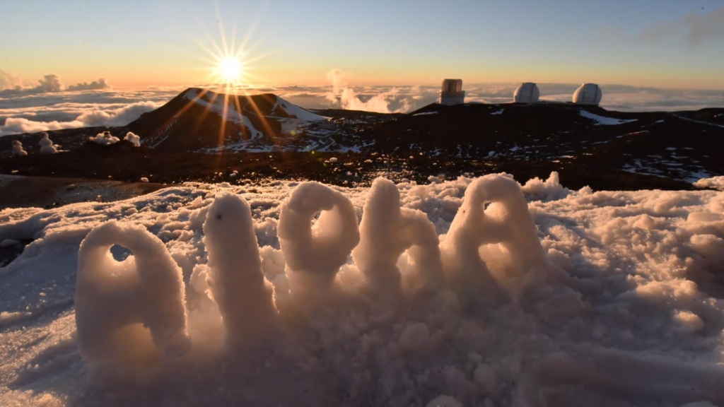 On mauna kea stargazing tours, visitors experience sunrise above the clouds at the snowy Mauna Kea summit, with observatories and volcanic peaks rising over Hawaii’s dramatic high-altitude landscape