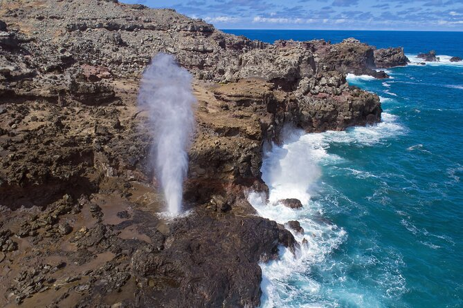 Halona Blowhole shooting seawater high above volcanic cliffs during a scenic stop on a circle island tour oahu.