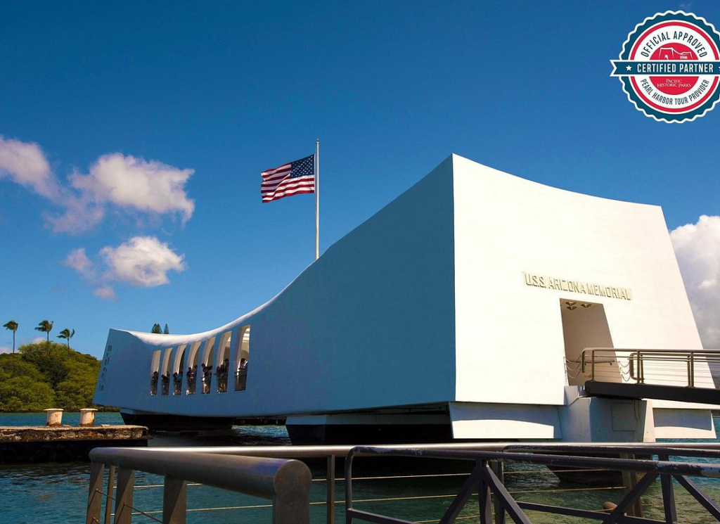 USS Arizona Memorial with American flag flying above the historic site, a highlight of pearl harbor tours at Pearl Harbor National Memorial in Hawaii.