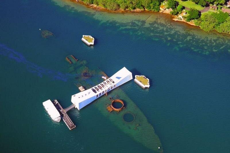 Aerial view of the USS Arizona Memorial above the sunken battleship in Pearl Harbor, one of the most powerful historic stops on pearl harbor tours in Hawaii.