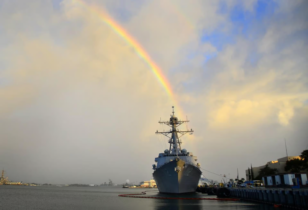 USS Bowfin submarine docked at Pearl Harbor with a rainbow overhead, a memorable historic stop featured on many pearl harbor tours in Honolulu.